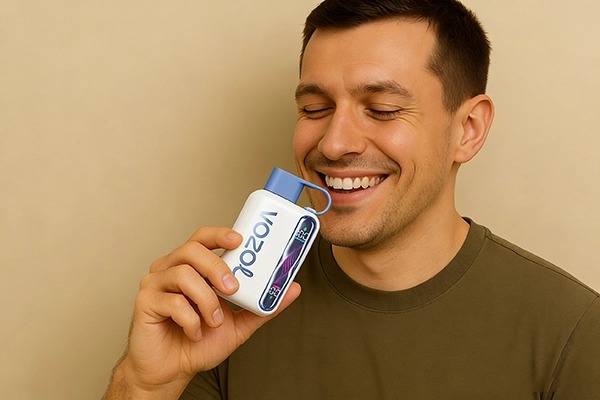 A person holding a Vozol branded disposable electronic cigarette with the label "40000 Puffs" in a beige background.